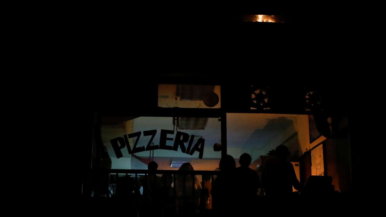 People eat by candlelight at a pizzeria during a second day of blackout in Caracas, Venezuela March 9, 2019