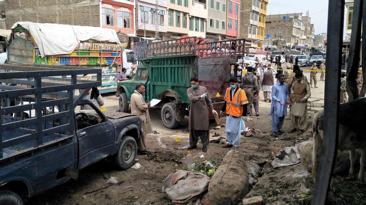 Members of the bomb disposal unit survey the site after a blast at a vegetable market in Quetta