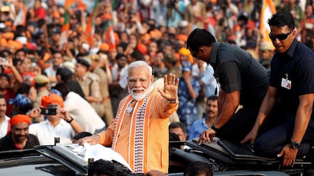 PM Modi waves towards cheered supporters during his roadshow in Varanasi