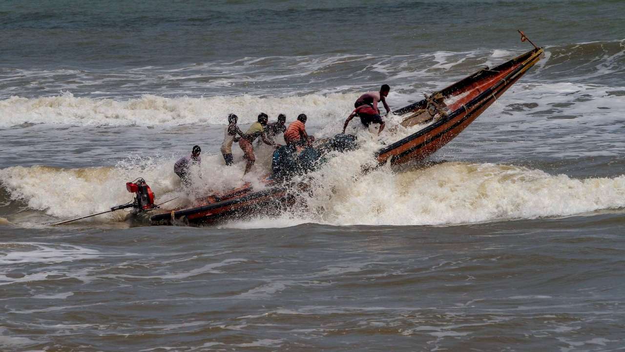 Fishermen try to control their boat amidst rough sea waters at Puri beach, Tuesday, April 30 2019