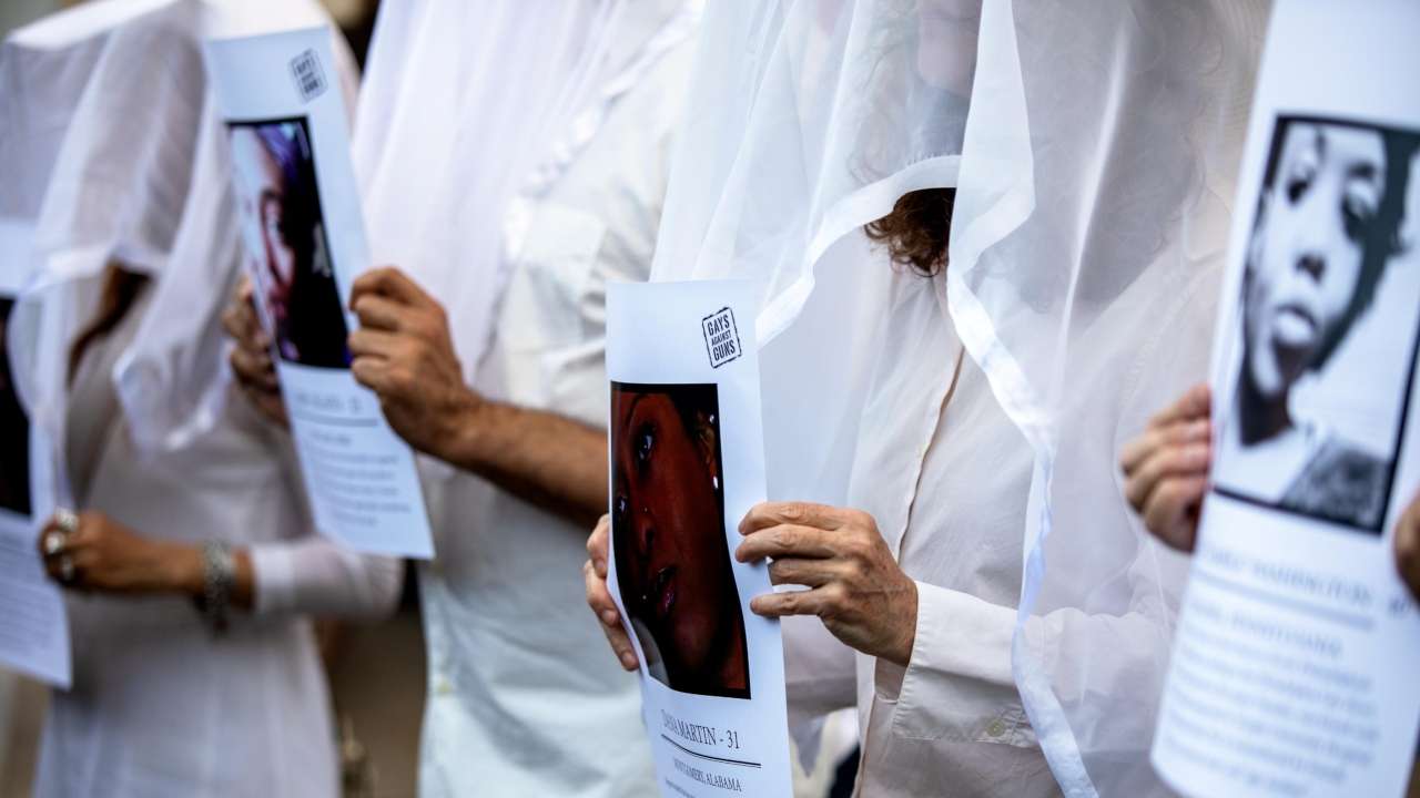 Transgender rights activists hold pictures of transgender women who were killed this year