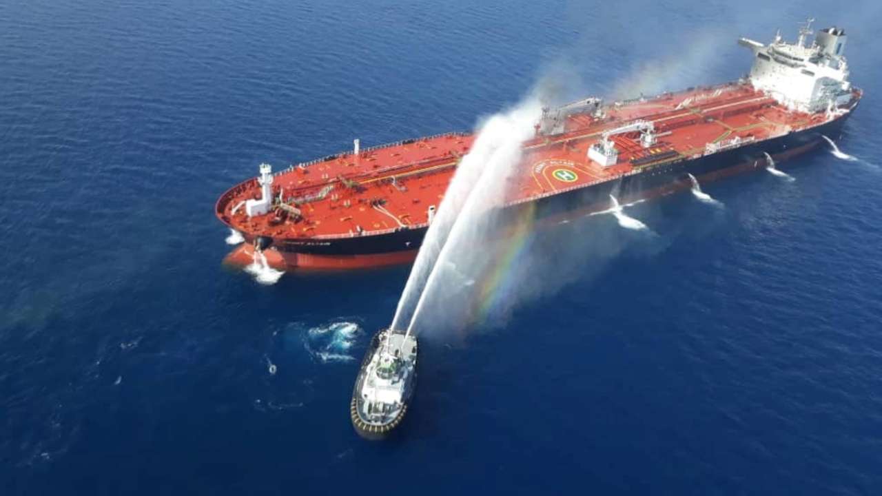 An Iranian navy boat tries to stop the fire of an oil tanker after it was attacked in the Gulf of Oman