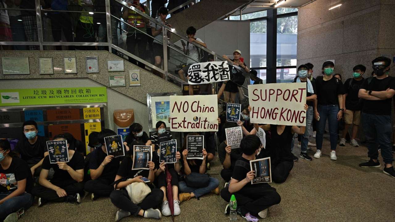 Protesters hold placards as they occupy the basement premises of Immigration Tower in Hong Kong on June 21, 2019. - Thousands of