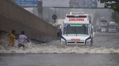 Ambulance moves slowly through a waterlogged road in Mumbai