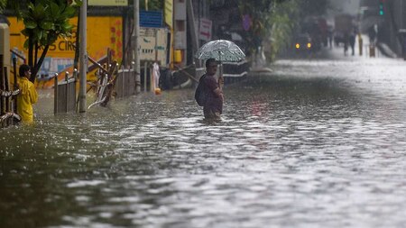 Man wades through a waterlogged street in Mumbai