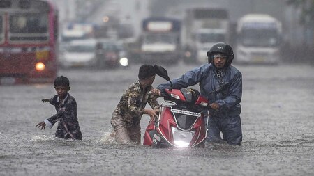 Commuters struggle to wade through waterlogged street