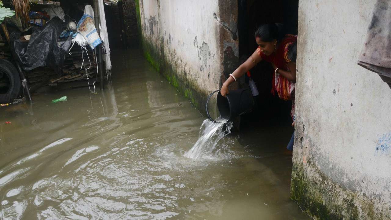 Woman throws water from her waterlogged house