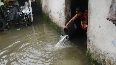 Woman throws water from her waterlogged house