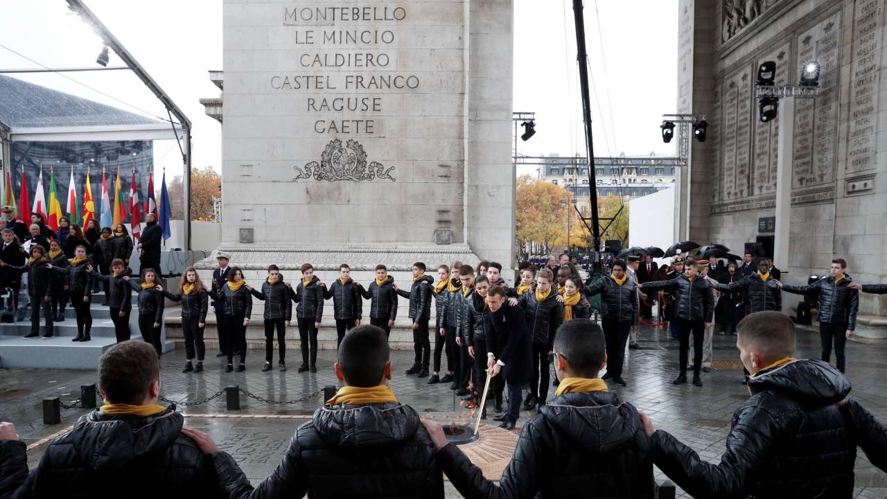 Emmanuel Macron re-lights the eternal flame at the Tomb of the Unknown Soldier