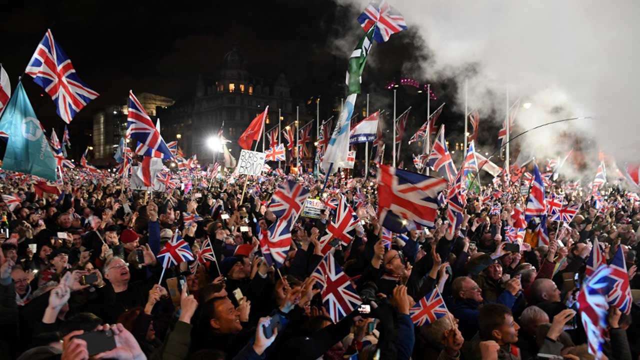 Brexit supporters wave Union flags as the time reaches 11 O'Clock, in Parliament Square, London