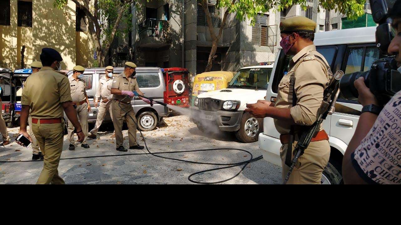 A Noida cop sanitising a vehicle