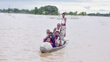 A family sails through the floodwaters in search of a safer place in Assam's flood-affected Nagaon district