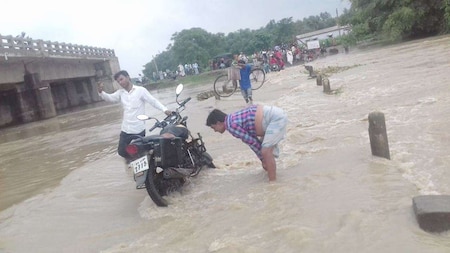 A person with a two wheeler stuck in water in Bihar's flood-affected Supaul district