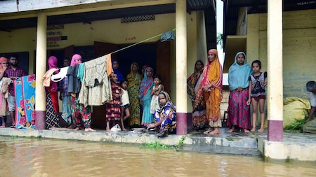 Villagers affected by a flood take shelter at a school, at Madhabpara village in Nagaon district