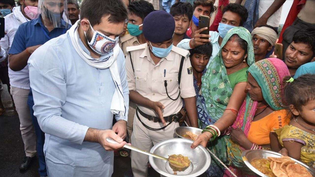 RJD leader Tejashwi Yadav distributes food among the flood victims in Bihar''s Darbhanga district