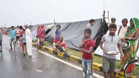 Flood victims wait for food outside their makeshift tents in Darbhanga district of Bihar