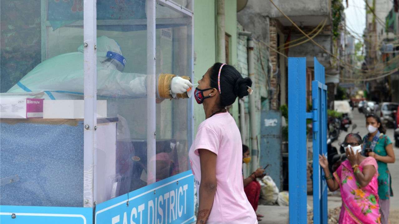 A health worker collects swab samples from people to test for COVID-19 infection 