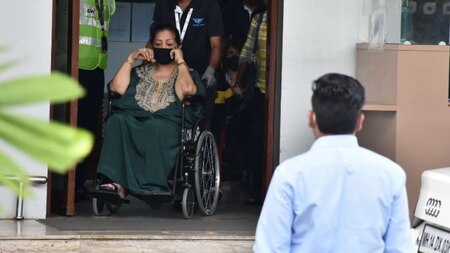 Hiroo Johar exits the airport on a wheelchair