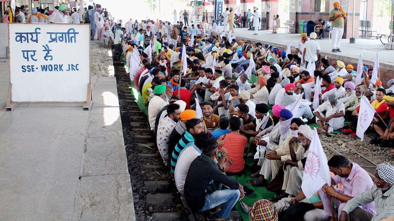 Farmers sitting on rail tracks
