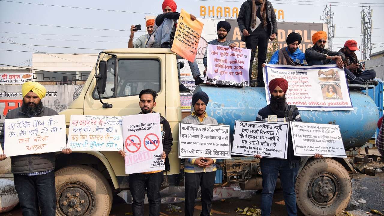 Farmers hold placards  to protest against farm laws at Singhu border