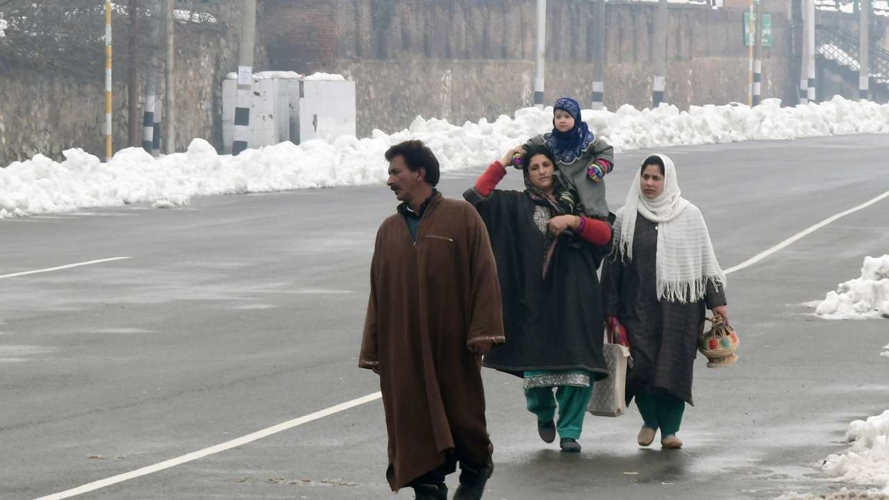 People walk on a road after a snowfall, in Srinagar on Sunday.
