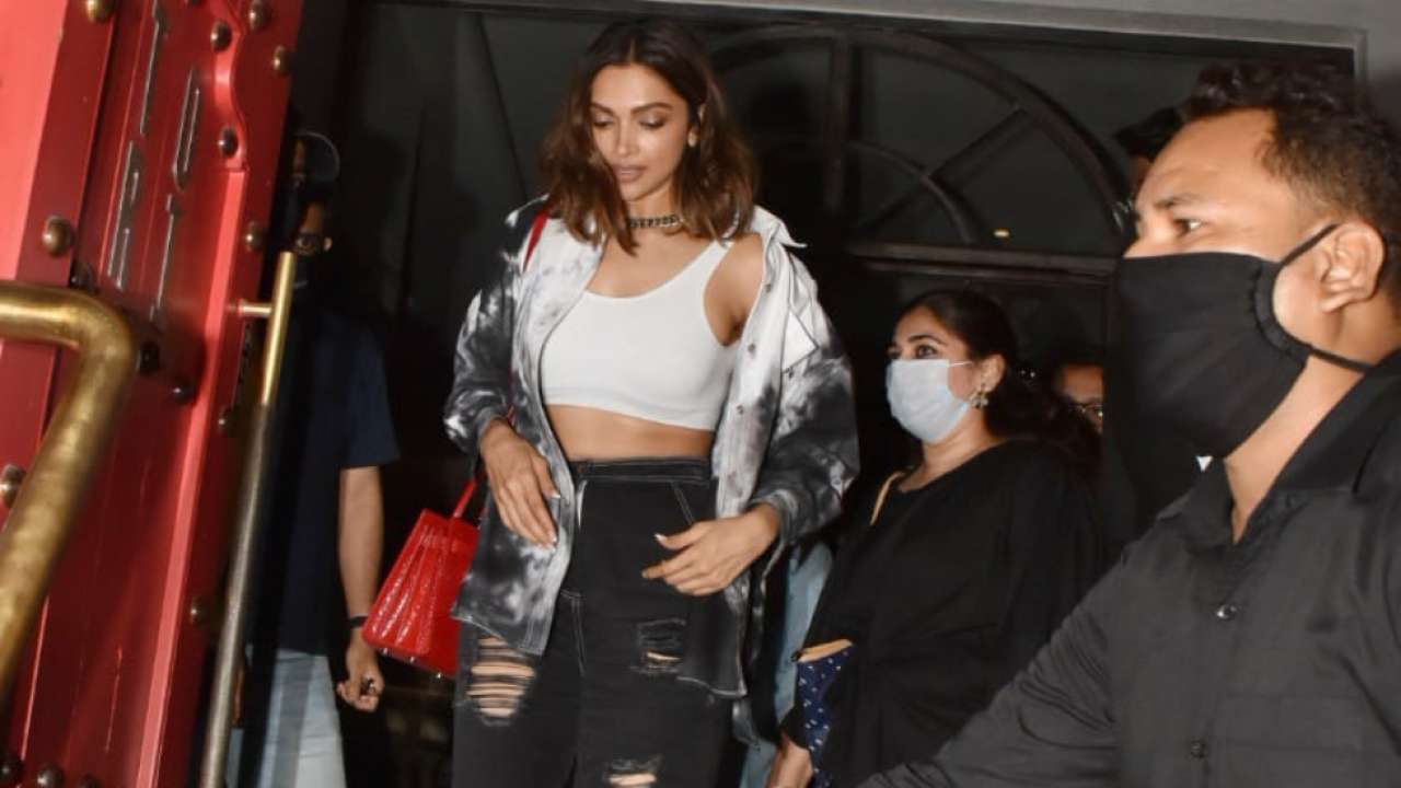 Deepika Padukone braves through the crowd of fans with smile on her face