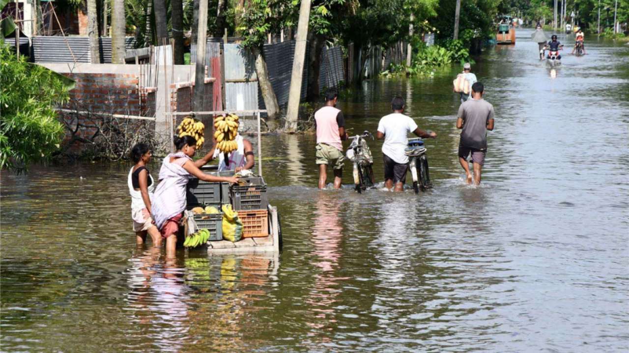 Villagers walk along flooded road