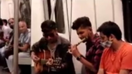 Men play flute and guitar in Delhi Metro