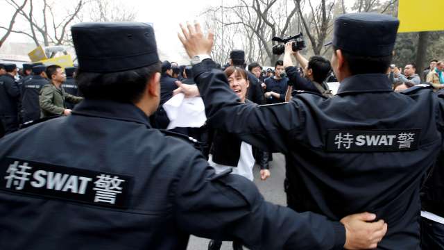 A family member of a passenger onboard Malaysia Airlines Flight MH370 shouts as policemen A family member of a passenger onboard Malaysia Airlines Flight MH370 shouts as policemen