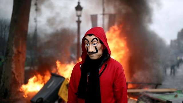 A protester stands in front of the barricade during riots at a "yellow vest" protest on the Champs-Elysees in Paris, France A protester stands in front of the barricade during riots at a "yellow vest" protest on the Champs-Elysees in Paris, France