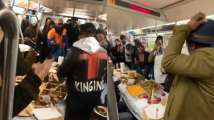 New York: Subway riders enjoy Thanksgiving dinner inside moving train,...
